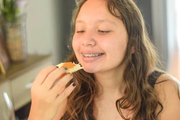 Happy teen eating pancakes with braces safely