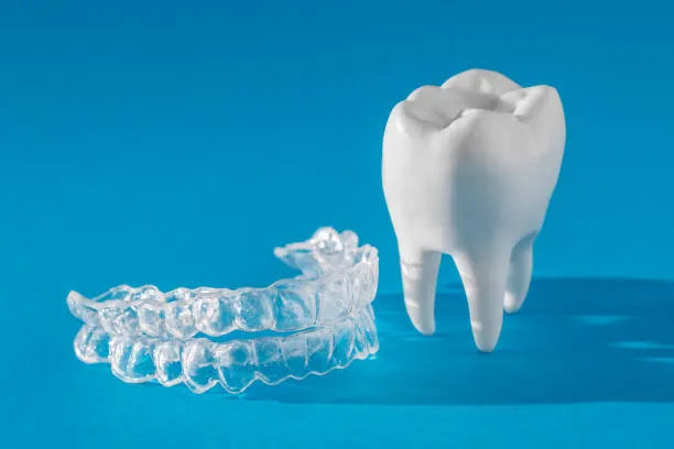 Invisalign aligners next to extracted wisdom teeth