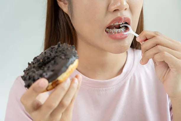 Person with braces enjoying a soft glazed donut safely