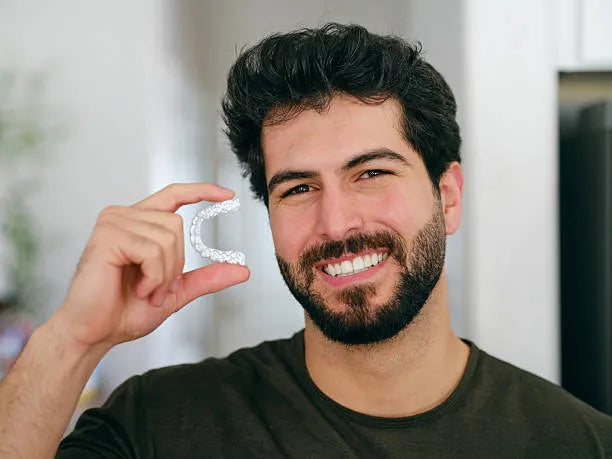 Smiling person holding a custom-fit night guard