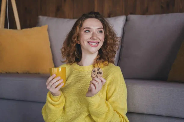 Woman enjoying soft cookie safely with braces