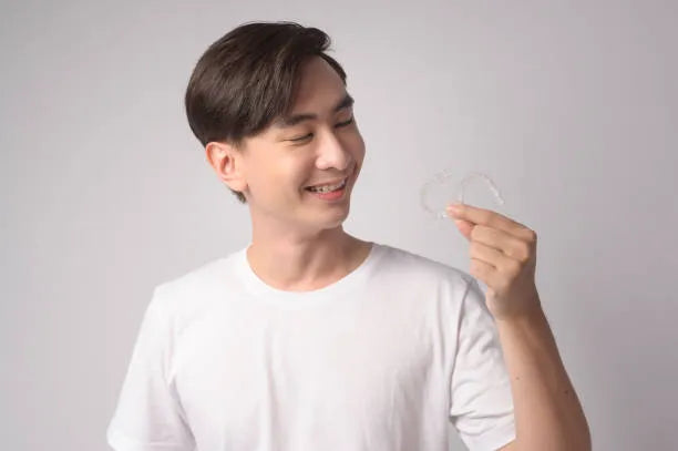 Person holding a clear retainer before wearing it