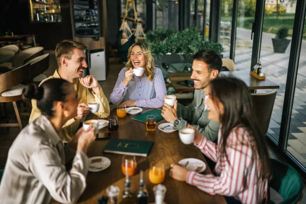 A group of friends enjoying coffee together at a cozy cafe, engaged in lively conversation and laughter