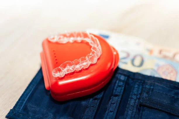 Transparent dental aligner for orthodontics on banknotes.